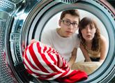 Man and woman looking inside dryer that has clogged dryer vent