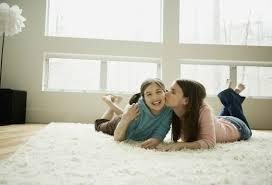 Two women laying on freshly cleaned carpet