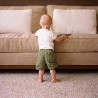 Toddler standing in front of clean couch