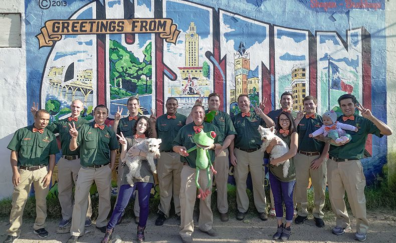 Peace Frog employees standing in front of "Greetings from Austin" wall graffiti